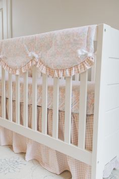 a baby crib with pink and white bedding