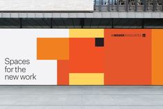 an orange and yellow advertisement on the side of a building with words spaces for the new work