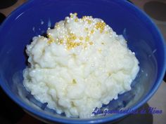 a blue bowl filled with rice and gold sprinkles on top of it