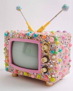 an old fashioned television decorated with beads and buttons