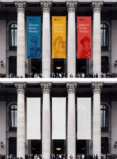 people are standing in front of two tall buildings with banners hanging from the side of them