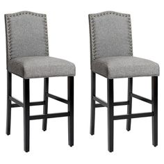 pair of grey upholstered barstools with studding