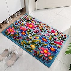 a pair of slippers sitting on the floor in front of a colorful door mat