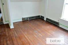 an empty room with hard wood flooring and white walls that have been stripped off