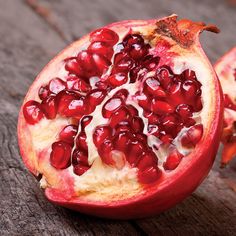 two pomegranates sitting on top of a wooden table next to each other