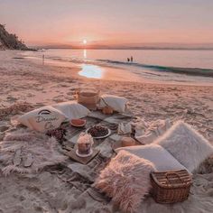 a picnic is set up on the beach at sunset