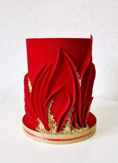 a red hat with gold sequins on the side and a white wall behind it