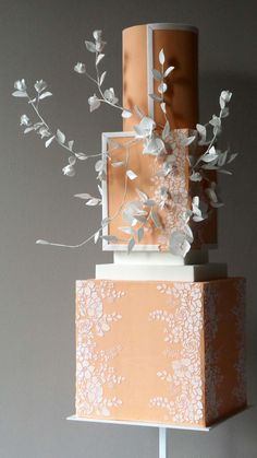 a three tiered cake with white flowers on top