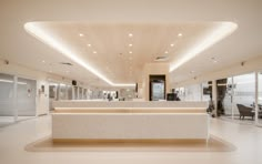 the interior of a modern office building with white marble counter tops and lights on the ceiling