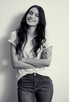 black and white photograph of a woman smiling with her arms crossed in front of her chest