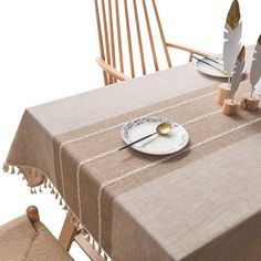 an image of a table setting with feathers on the plate and place settings for two