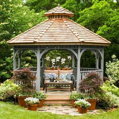 a wooden gazebo surrounded by potted plants