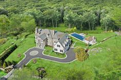 an aerial view of a large house in the middle of a lush green forest area