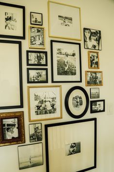 a wall filled with lots of framed pictures