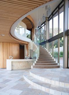 a staircase leading up to the upper level of a house with glass walls and wood paneling