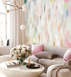 a living room filled with furniture and a large painting on the wall above it's coffee table