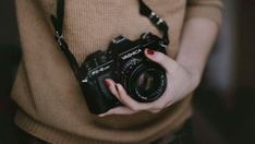 a woman holding a camera in her hands