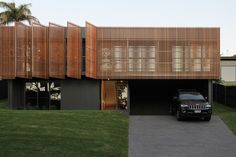 a black jeep parked in front of a wooden structure on the side of a house