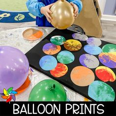 a young boy is playing with balloons and paper plates