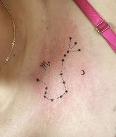 a woman's chest with a star and moon tattoo on her left side breast