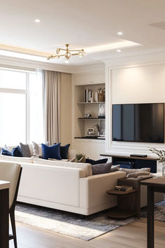 a living room filled with furniture and a flat screen tv mounted on a wall above a fireplace