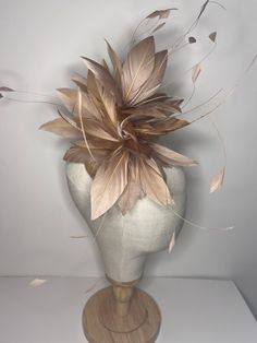 Gold Feather Puff fascinator is a stunning accessory made from high-quality goose nagorie and coque feathers. The feathers are expertly arranged in a circular shape to create a voluminous and fluffy look, perfect for adding a touch of glamour to any outfit. The feather puff is attached to a sinamay base, which adds structure and stability to the design. The base is then securely attached to a color-coordinated headband, making it easy to wear and comfortable to keep in place. 🖤This head piece looks simply stunning and is perfect for weddings, special occasions or a day at the races.  🖤All head pieces are finished with matching headband wrapped in co-ordinating silk ribbon or secure millinery elastic which is comfortable and easy hidden. 🖤Shipped in a sturdy (keepsake) box and packed wit Feather Hair Accessories For Wedding And Kentucky Derby, Feathered Hair Accessories For Wedding At Kentucky Derby, Wedding Fascinator With Feathers In Beige, Gold Wedding Fascinator With Feathers, Brown Adjustable Wedding Headpiece, Adjustable Brown Wedding Headpieces, Adjustable Brown Headpieces For Wedding, Gold Fascinator, Headband Making