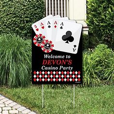 a lawn sign that says, big winners welcome with four playing cards on it in front of some bushes