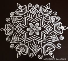 an intricate design on a black surface with white chalk and colored pencils in it