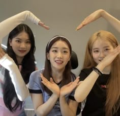 three girls are posing with their hands in the air