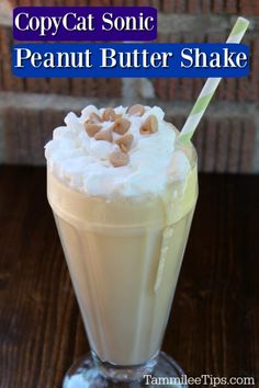 copycat sonic peanut butter shake with whipped cream and cashews in it on a wooden table