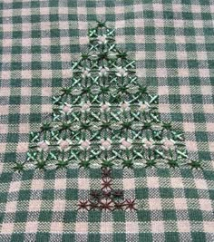 a green and white checkered table cloth with a small christmas tree on it