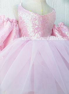 Our Ballerina Couture dress features a super voluminous skirt, sparkly sequin bodice with a beautiful criss cross back that makes it perfect and adjustable giving it room for growth and an off the shoulder poofy sleeve. Our dresses usually tend to fit a size up and a size down, perfect for photographers client closets. Handmade to order in the USA. Customs welcomed Select the color you would like from the drop down. Menu, We also have Black, Red, Royal Blue, Yellow, mostly any color, send us a m Summer Pageant Dress With Sequins, Pink Glitter Dress For Wedding, Pink Glitter Dresses For Wedding, Sequin Tulle Dress For Pageants, Spring Princess Style Fitted Ball Gown, Summer Ball Gown For Dress-up Events, Summer Ball Gown For Dress-up, Fitted, Princess Style Fitted Ball Gown For Spring, Fitted Princess Ball Gown For Spring