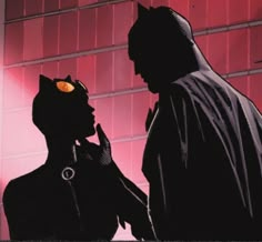 batman and catwoman standing next to each other