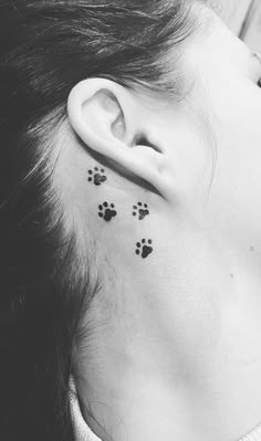 a woman's ear with small paw prints on it