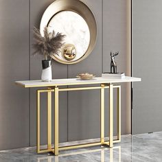 a console table with a black marble top and gold metal legs, in front of a round mirror