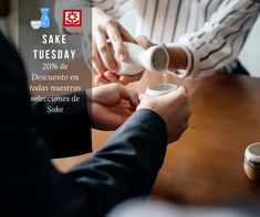 two people sitting at a table pouring something into a cup