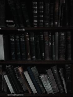 an old bookshelf filled with lots of black books