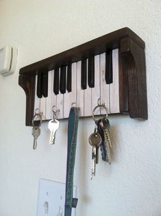 keys are hanging on a key rack that is attached to the wall and hangs from it's sides