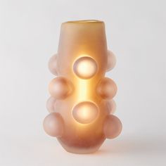 a glass vase that has some balls in the shape of an object on top of it