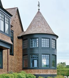 a large brown house with a tower on the top and two windows in it's corner