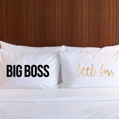 two pillows that have the words big boss and little boss on them sitting on a bed