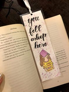 an open bookmark with the words you feel asleep here on it, and a hand holding