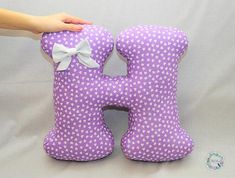 a purple stuffed animal with white polka dots and a bow on it's back