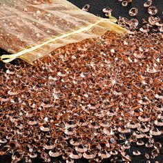 a bag filled with lots of brown and white sequins on top of a black surface