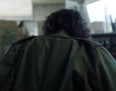 the back of a man's head is covered by a green cape