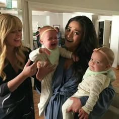 three women and one baby are smiling at the camera