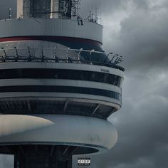 an airplane is flying over the top of a tall building with clouds in the background