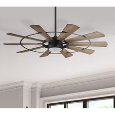 a ceiling fan with wooden blades hanging from it's center point in a room