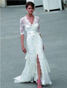 a woman in a white dress is standing on the street