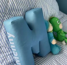 a stuffed animal sitting on top of a blue pillow next to a stuffed toy elephant